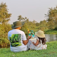 a man and a little girl sitting on the grass