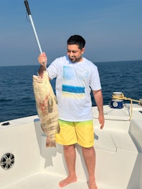 a man holding a large fish on a boat