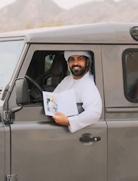 a man sitting in the driver's seat of a land rover